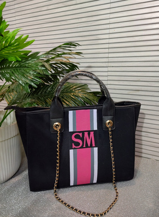 Black bag with white, grey and pink stripes